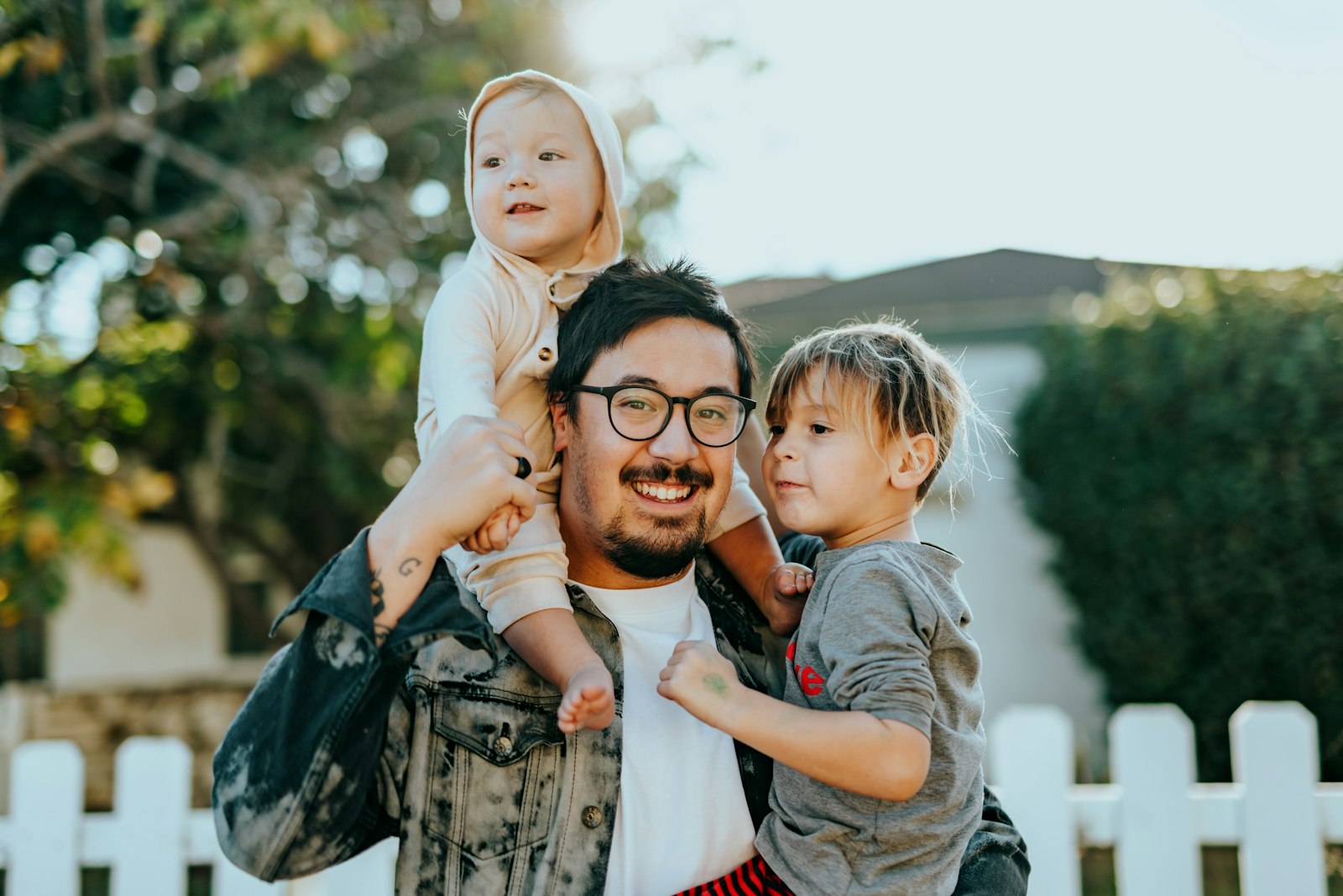 Papá con sus dos hijos frente a la fachada de su nueva casa