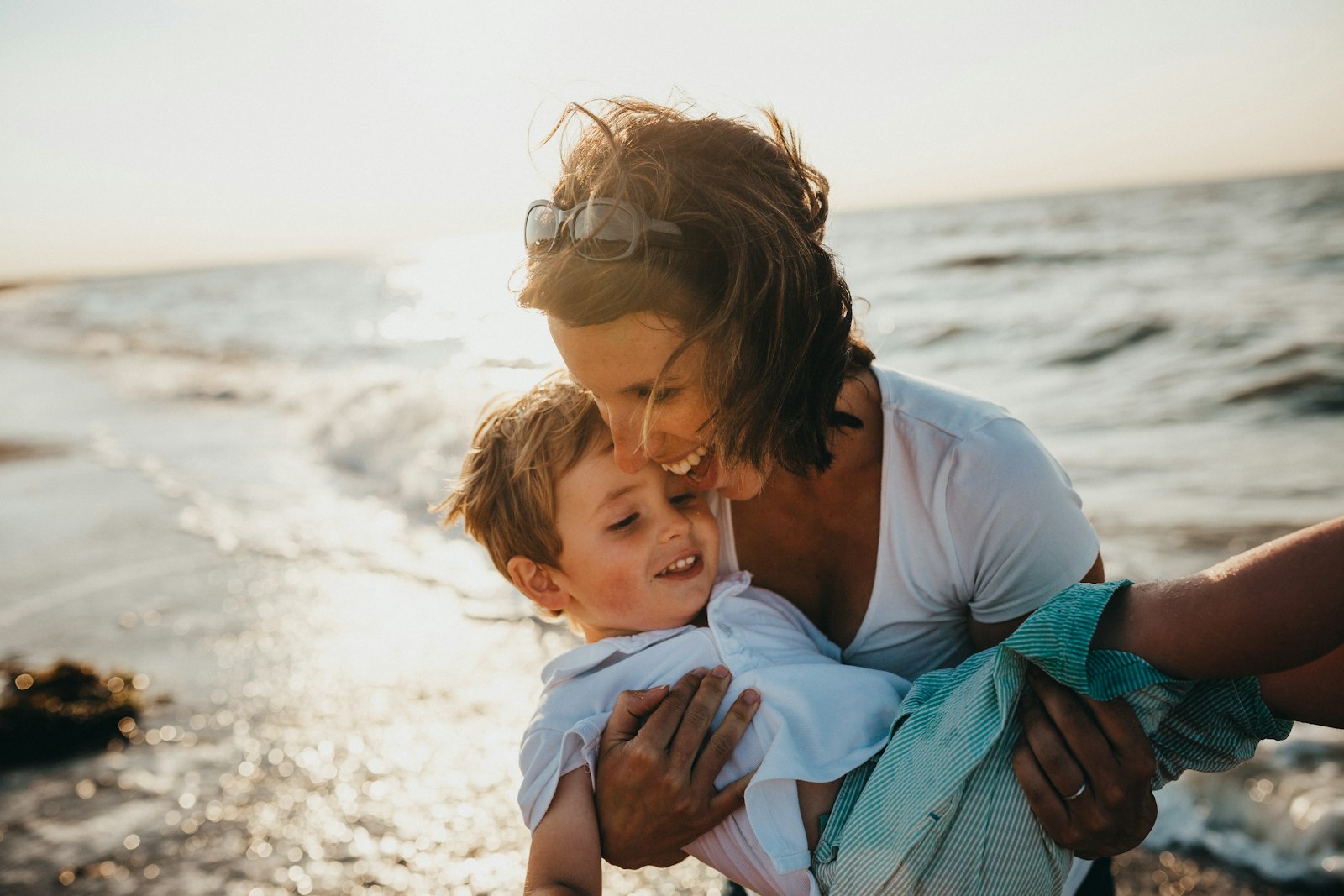 Mamá abrazando con cariño a su hijo, felices al aire libre