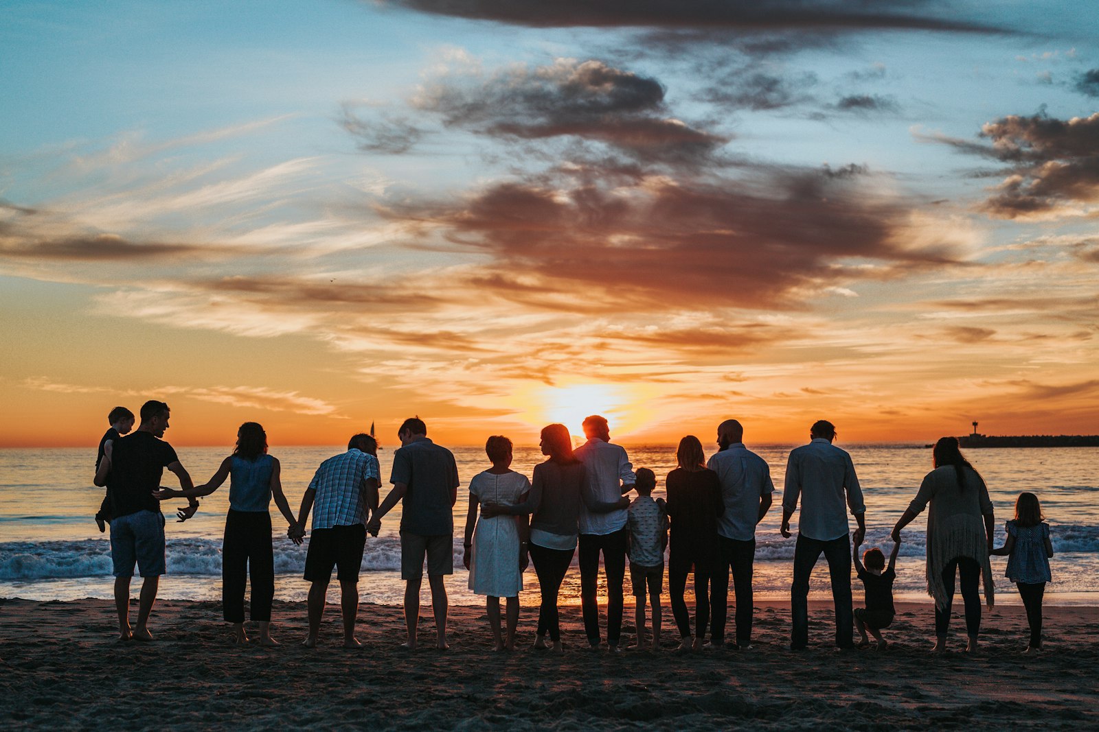 Familia reunida y feliz al atardecer frente al mar